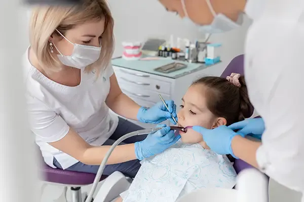 Dentist performing a root canal treatment on a young child in a dental clinic.