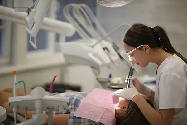 Dentist performing a restorative dental procedure on a patient in a modern dental clinic setting.